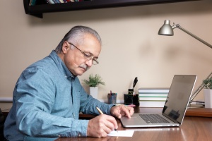 Senior man looking on computer at home
