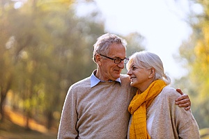 a couple walking in the park after making a mortgage payment through their life insurance plan