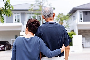 a senior couple looking at their house after paying off their mortgage with life insurance