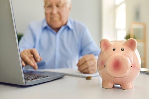 man reviewing investments with a piggy bank on his desk