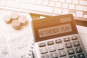 retirement plan concept with a calculator and coins on a desk