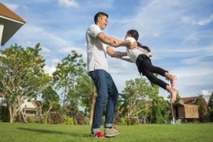 man playing with his daughter in yard