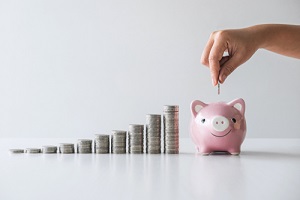 stacking coins pile next to a piggy bank for planning step up to growing and savings with money box