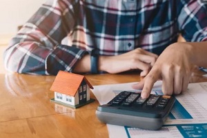 man with calculator and home dummy